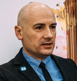 Serhii Lukashov, leder i SOS-barnebyer Ukraina. Han har kortbarbert sveis, blå skjorte, svart slips og dressjakke. Foto SOS-barnebyer Ukraina