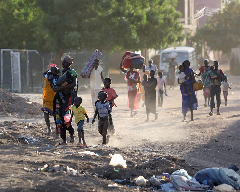 Sudan: Kvinner og barn som flykter fra kampene i Khartoum, de bærer eiendelene sine på hodet. Foto: AFP